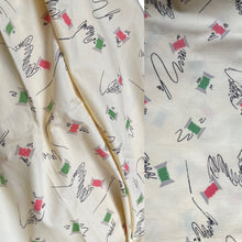 Load image into Gallery viewer, Original 1940’s Novelty Print Cotton Dress Fabric in Buttermilk with Cotton Reels in Pink and Green and Black Sewing Needles and Thread