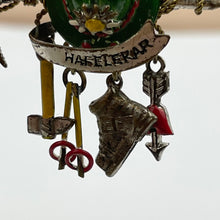 Load image into Gallery viewer, 1940s Painted Metal Austrian Tourist Brooch with Hat, Walking Canes, Boot, Pickaxe and Arrow with a Love Heart