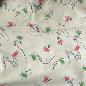 Original 1940’s Novelty Print Cotton Dress Fabric in Buttermilk with Cotton Reels in Pink and Green and Black Sewing Needles and Thread