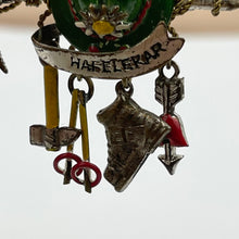 Load image into Gallery viewer, 1940s Painted Metal Austrian Tourist Brooch with Hat, Walking Canes, Boot, Pickaxe and Arrow with a Love Heart
